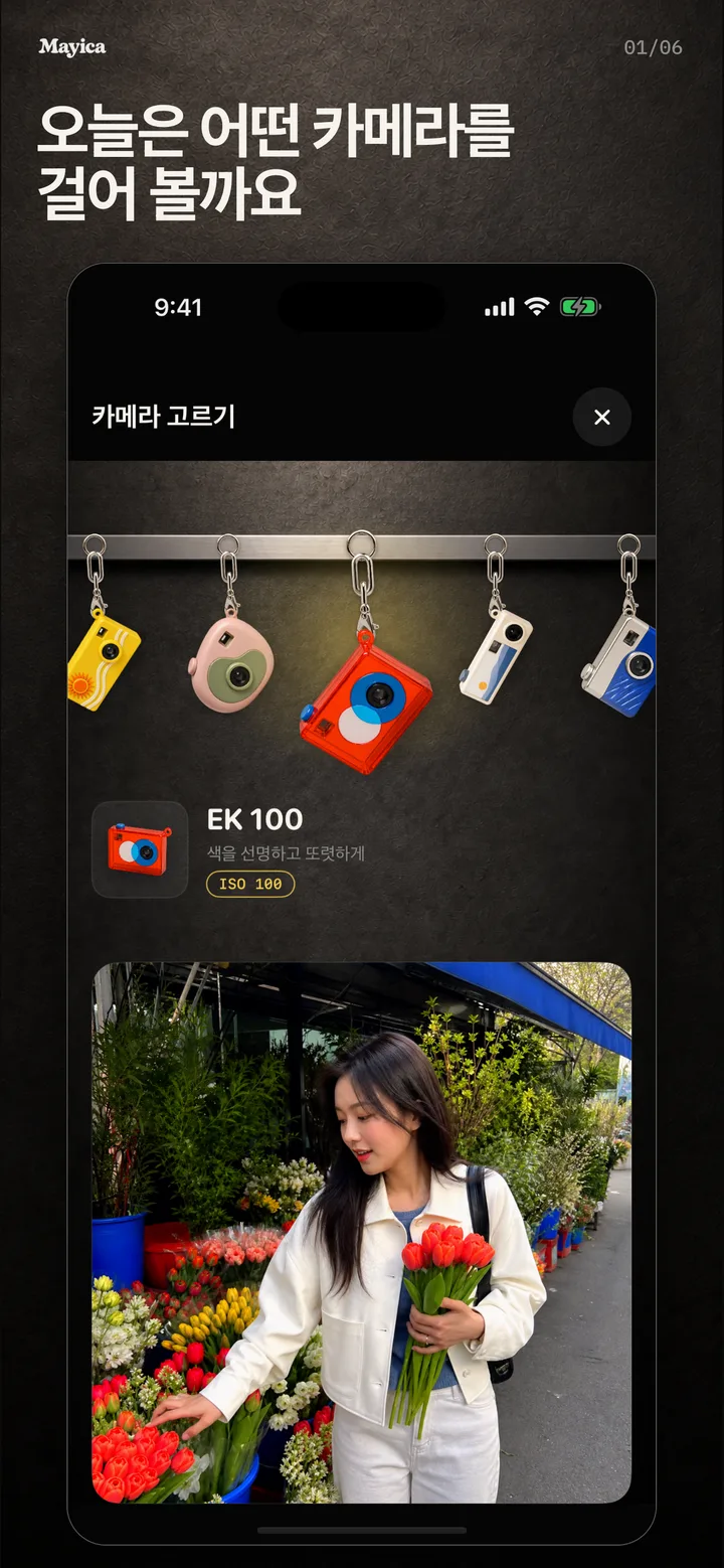 카메라 고르기 화면. 금속 레일에 카메라 키링이 걸려 있고 아래에 선택한 카메라의 사진이 보인다.
